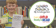 Young boy holding the 1000 Books by Kindergarten certificates